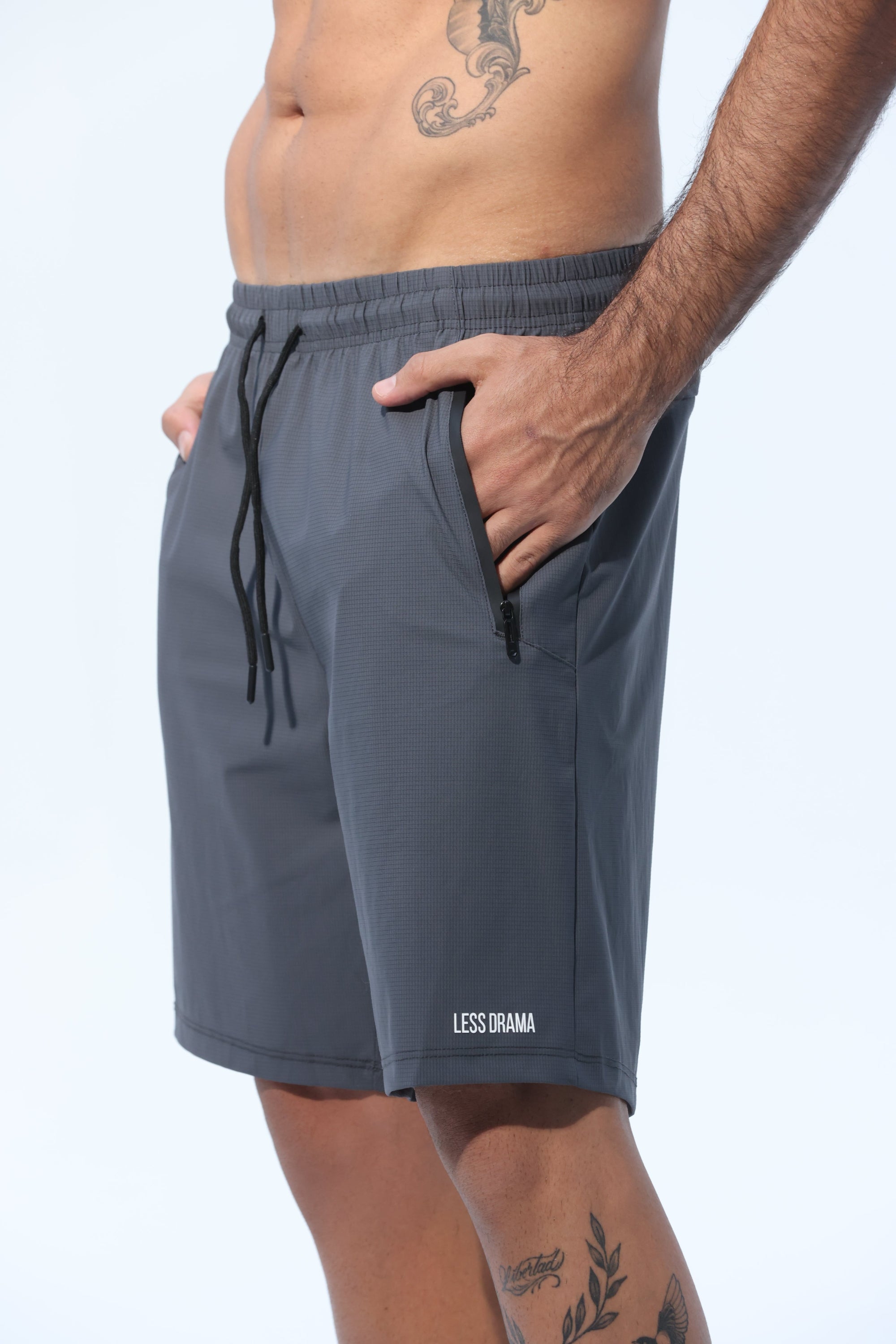Person wearing gray shorts with a visible brand logo on a white background