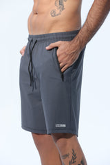 Person wearing gray shorts with a visible brand logo on a white background